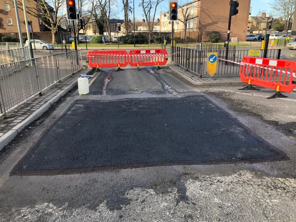 A highway reinstatement at a junction, barriered off during the works