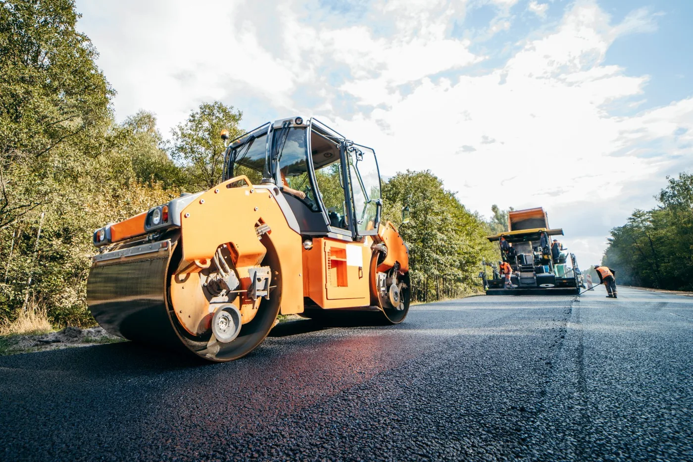 A roller and paver laying a new road surface