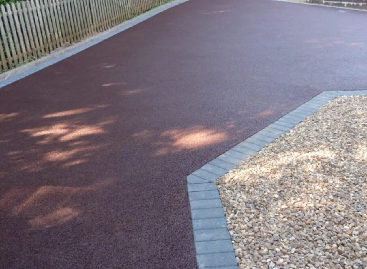 A red-finished surface edged with block paving and gravel