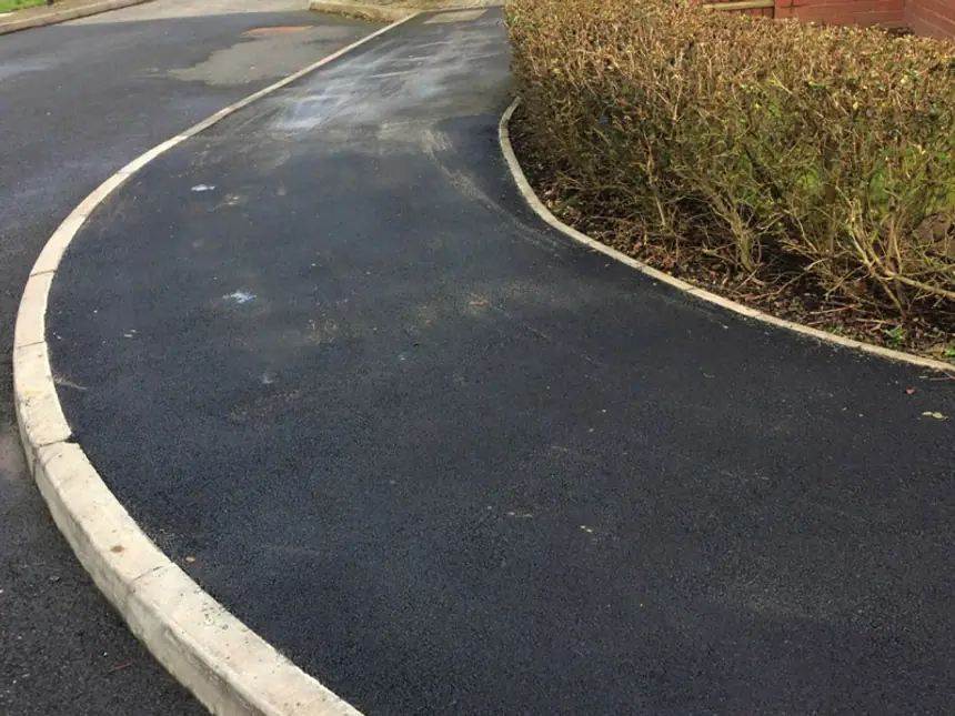 A new tarmac footpath with a fresh kerb edge