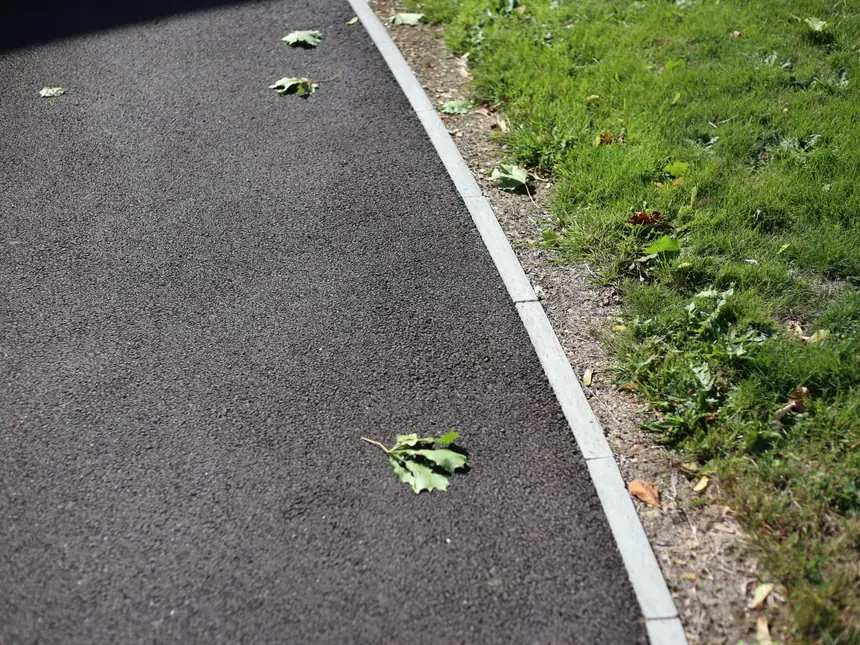 A path edged where the tarmac meets the grass