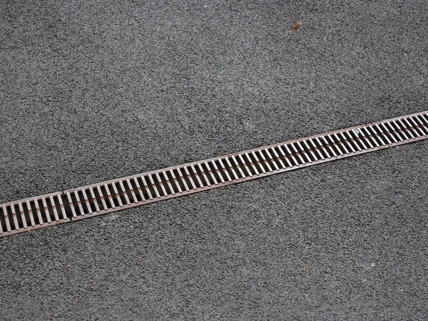 A drainage channel set into a tarmac path