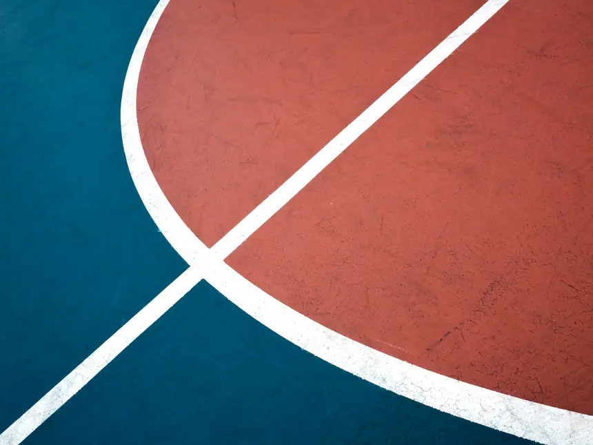 A coloured sports surface with white line markings