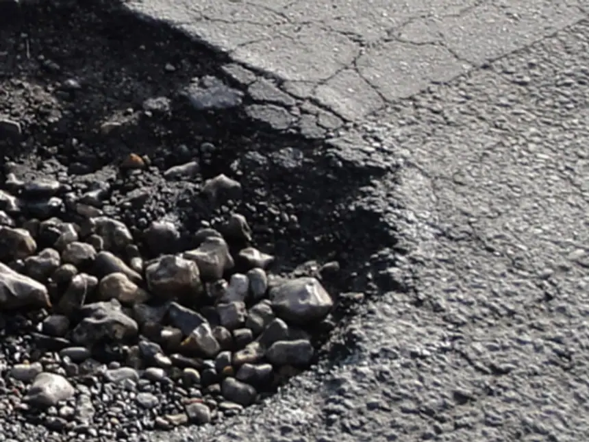 An operative alongside a freshly filled pothole