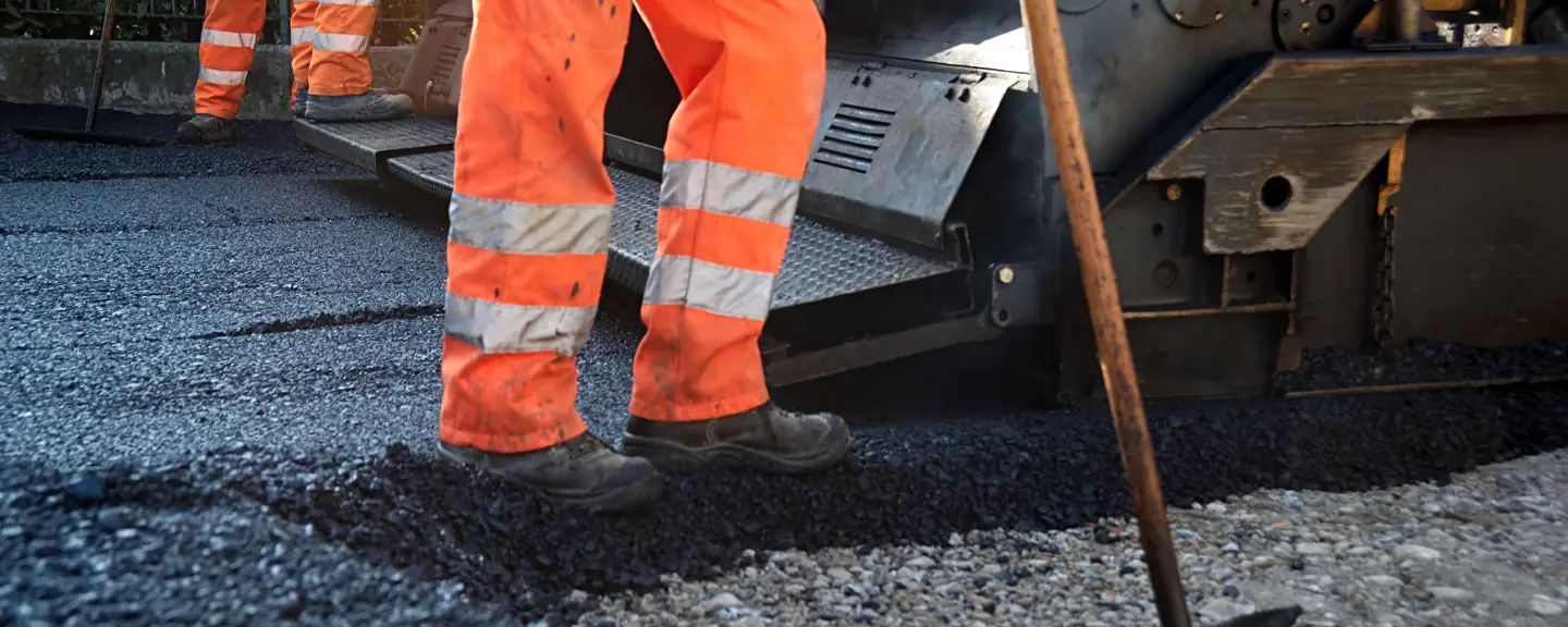 A road crew raking out hot asphalt — Road Resurfacing in Bexley by Meads Resurfacing