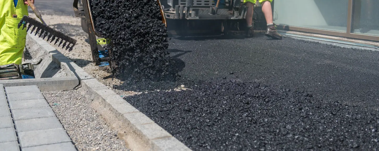 A new asphalt course laid up to the kerb line — Road Resurfacing in Hackney by Meads Resurfacing