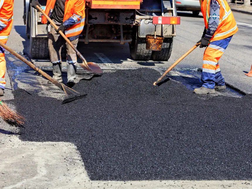 A crew shovelling asphalt into place