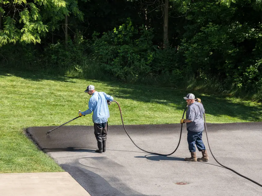 Bitumen sealant being squeegeed across a surface