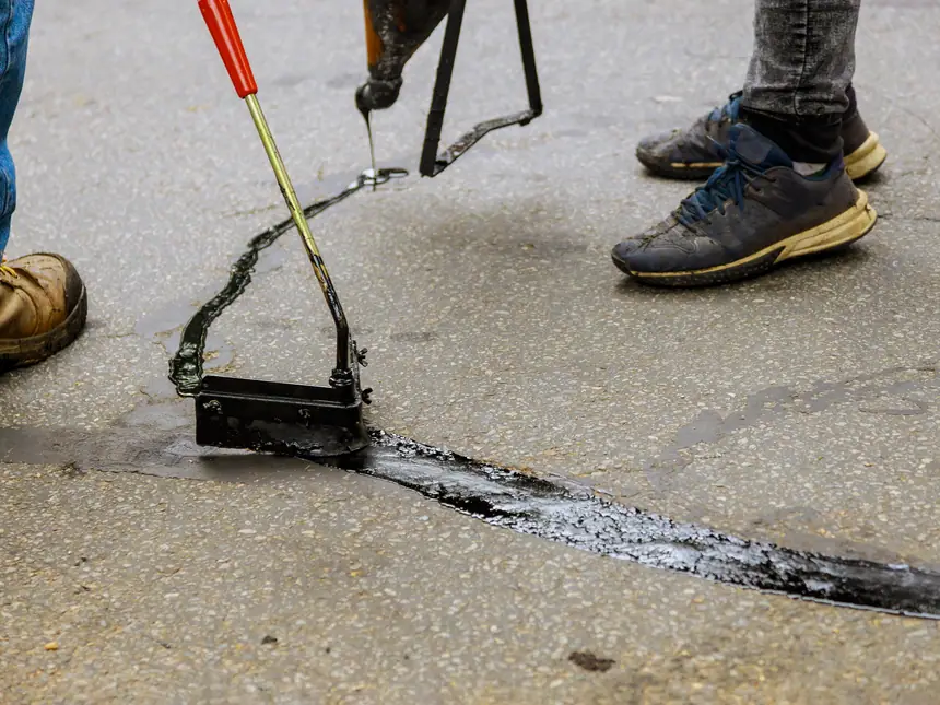 A crew treating a worn asphalt surface