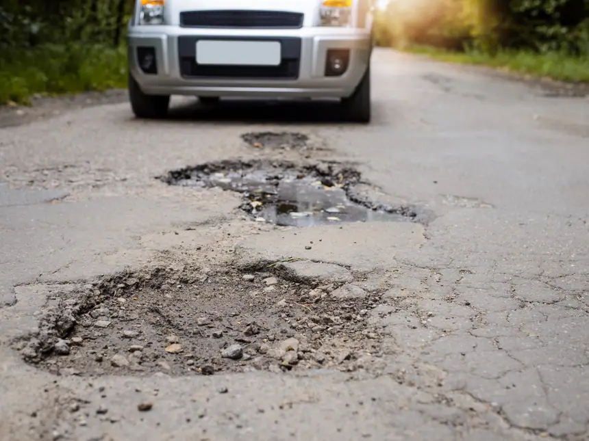 A road surface failing around an old repair
