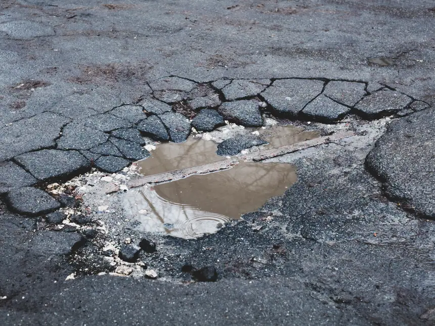 A pothole forming in a worn carriageway