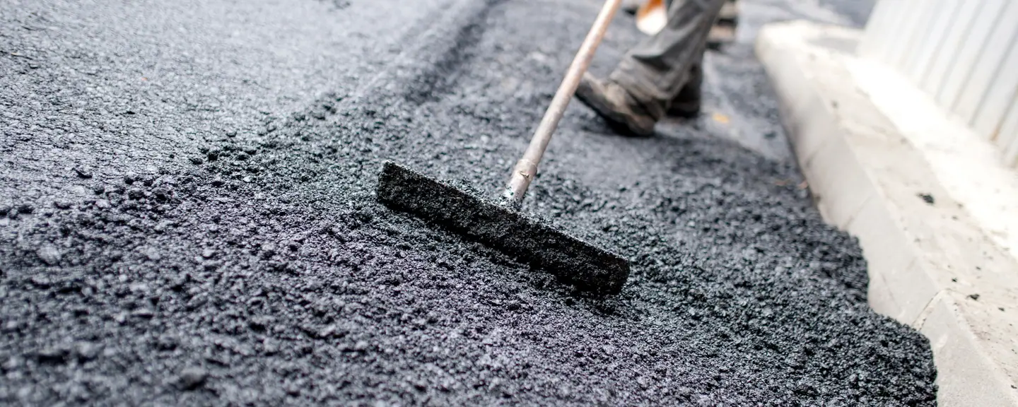 A contractor raking tarmac level — Tarmac Contractors in Tottenham by Meads Resurfacing