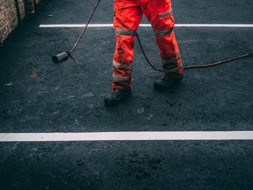 A contractor working alongside a painted line