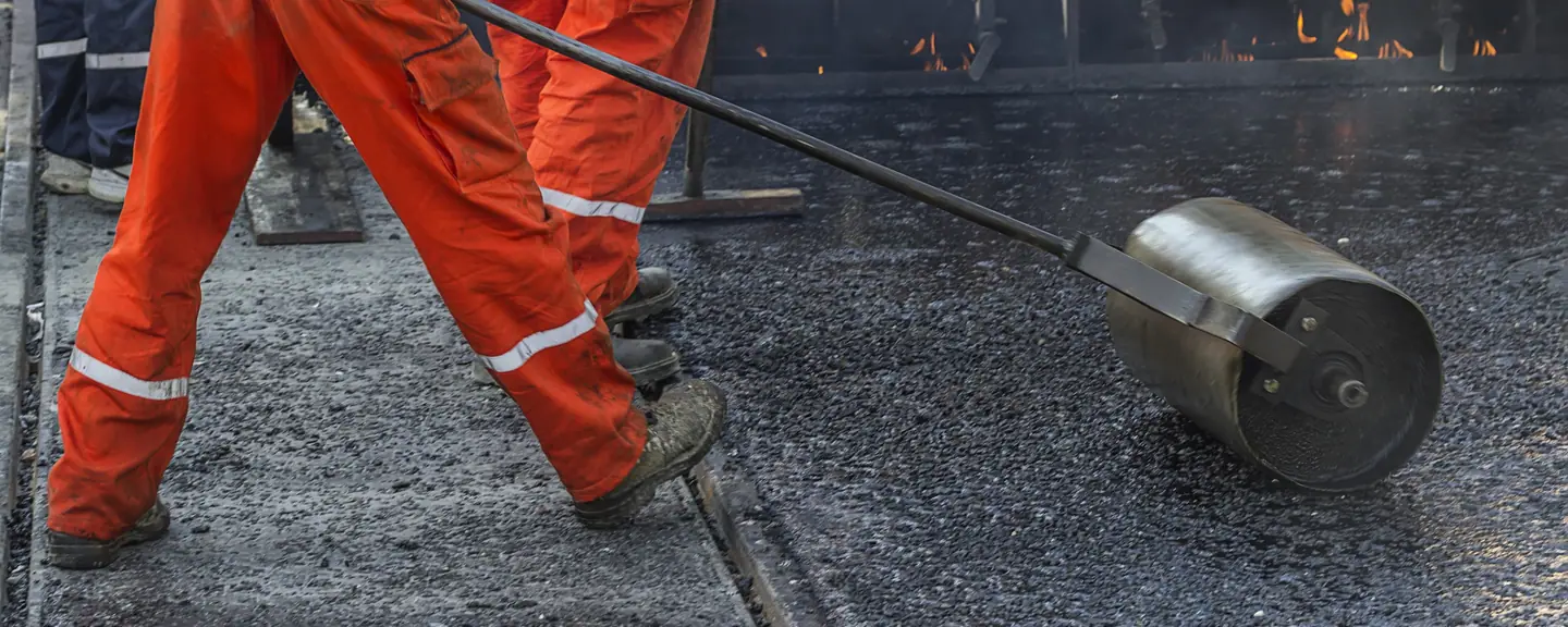 Tarmac being tamped against a kerb — Tarmac Contractors in Barking by Meads Resurfacing