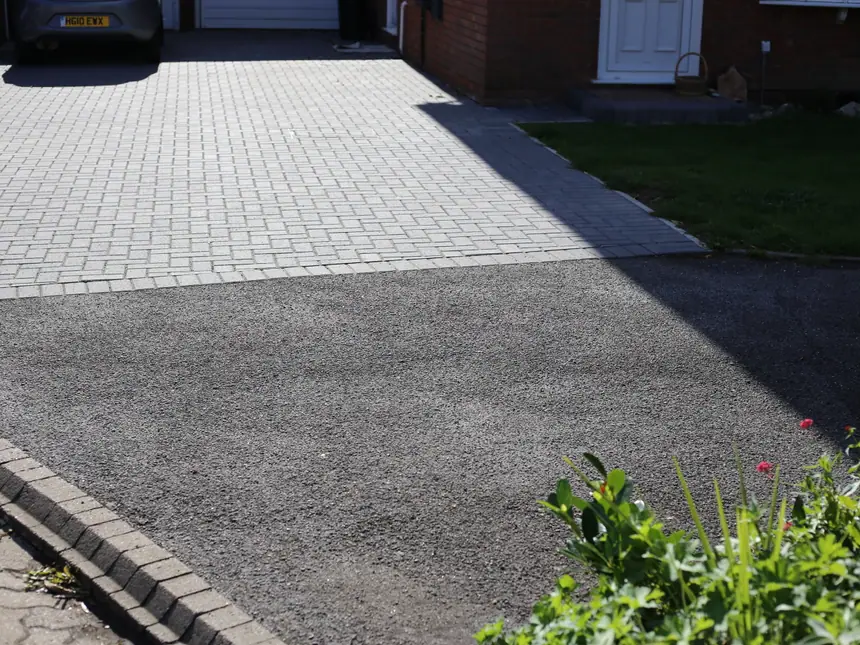 A tarmac driveway edged with block paving