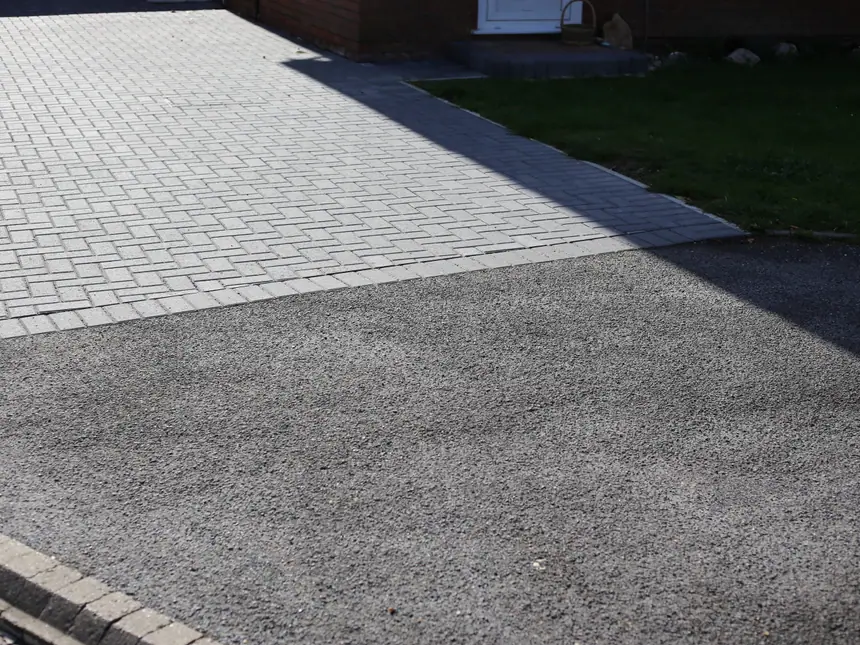 A wide tarmac driveway with a block paved border