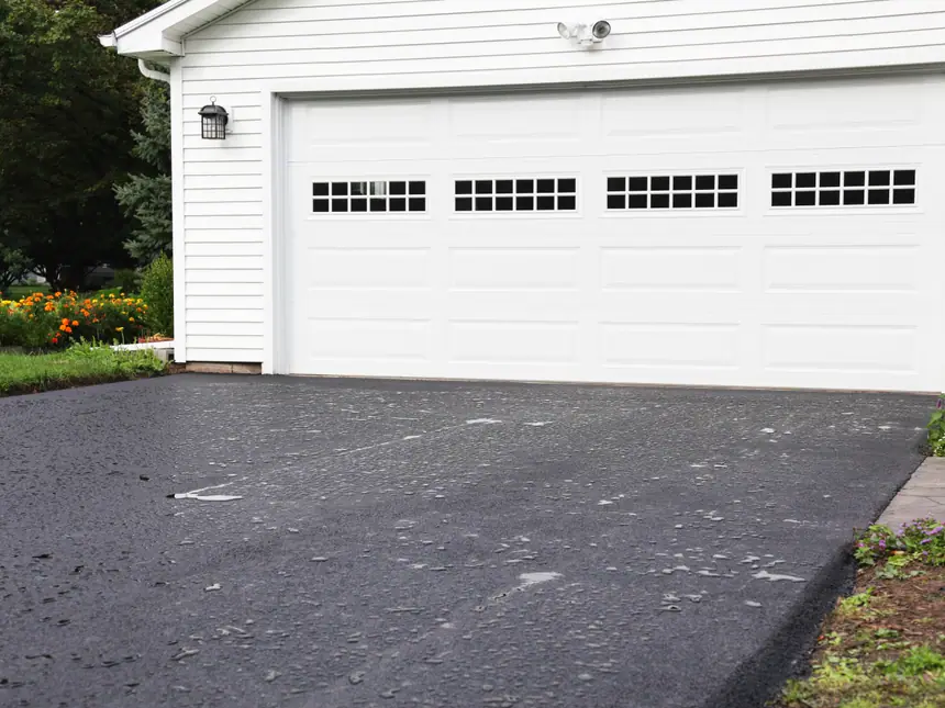 A tarmac driveway up to a double garage